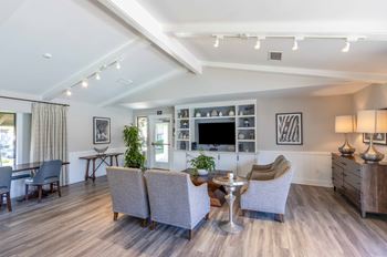 a living room with couches and chairs and a tv